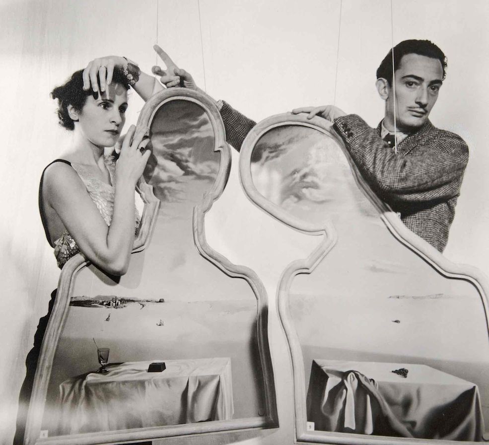 Foto de Cecil Beaton de Gala i Dalí darrera de l'obra Parella amb els caps plens de núvols